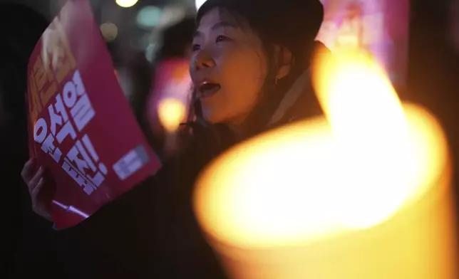 A woman shouts slogans during a candlelight vigil against South Korean President Yoon Suk Yeol in Seoul, South Korea, Thursday, Dec. 5, 2024. (AP Photo/Lee Jin-man)