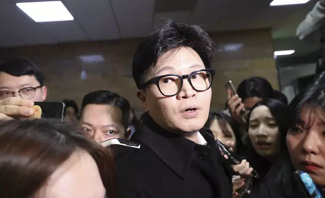 South Korea's ruling People Power Party leader Han Dong-hun, center, is surrounded by the media at the National Assembly in Seoul, South Korea, Friday, Dec. 6, 2024. (Park Dong-ju/Yonhap via AP)