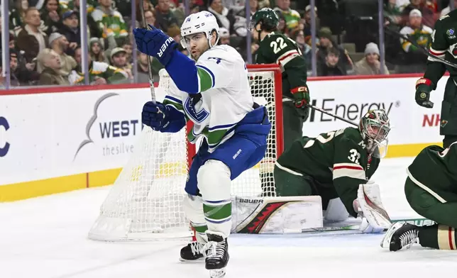 Vancouver Canucks left wing Jake DeBrusk, left, celebrates after scoring a goal past Minnesota Wild goalie Filip Gustavsson during the second period of an NHL hockey game Tuesday, Dec. 3, 2024, in St. Paul, Minn. (AP Photo/Craig Lassig)