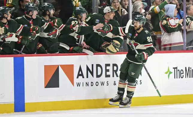 Minnesota Wild center Frederick Gaudreau celebrates with the bench after scoring a goal against the Vancouver Canucks during the second period of an NHL hockey game Tuesday, Dec. 3, 2024, in St. Paul, Minn. (AP Photo/Craig Lassig)