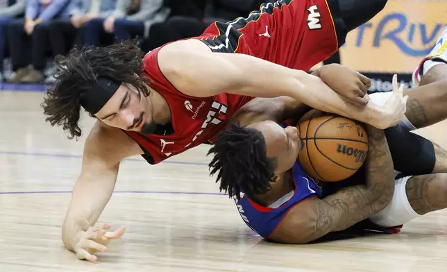 Detroit Pistons forward Ronald Holland II, right, and Miami Heat guard Jaime Jaquez Jr., left, battle for the ball during the first half of an NBA basketball game Monday, Dec. 16, 2024, in Detroit. (AP Photo/Duane Burleson)