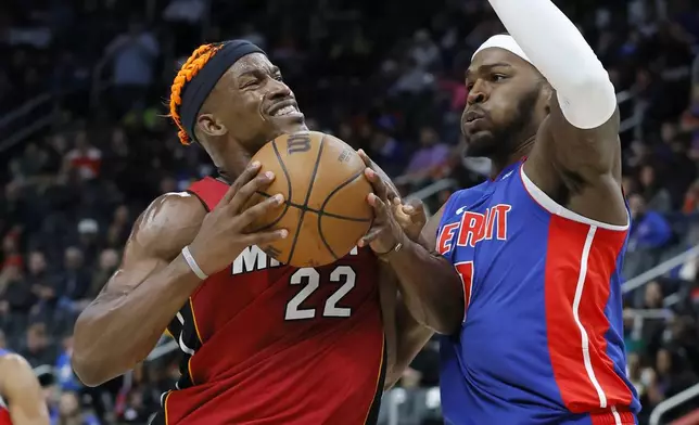 Miami Heat forward Jimmy Butler (22) drives to the basket against Detroit Pistons forward Paul Reed, right, during the first half of an NBA basketball game Monday, Dec. 16, 2024, in Detroit. (AP Photo/Duane Burleson)