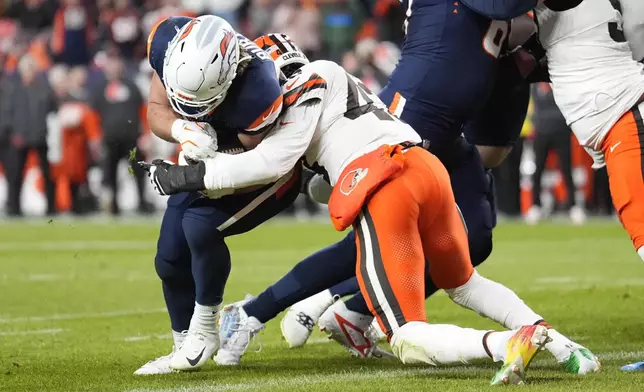 Denver Broncos fullback Michael Burton (20) breaks from Cleveland Browns linebacker Mohamoud Diabate (43) to score from 1-yard during the first half of an NFL football game, Monday, Dec. 2, 2024, in Denver. (AP Photo/Jack Dempsey)