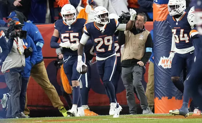 Denver Broncos cornerback Ja'Quan McMillian (29) celebrates his 46-yard interception return for a touchdown during the second half of an NFL football game against the Cleveland Browns, Monday, Dec. 2, 2024, in Denver. (AP Photo/Jack Dempsey)