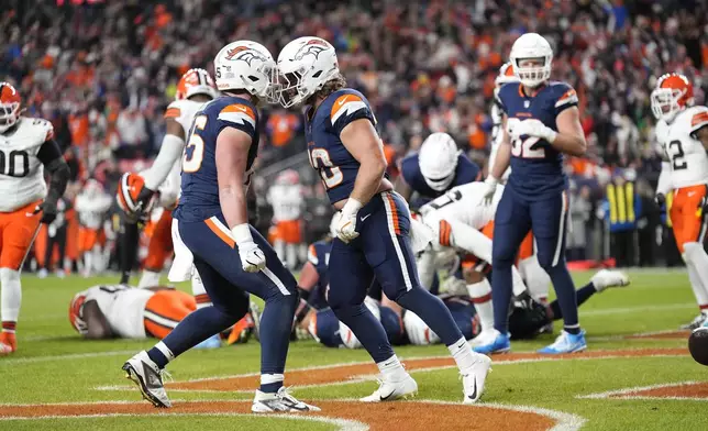 Denver Broncos fullback Michael Burton, right, celebrates his 1-yard rushing touchdown with teammate tight end Nate Adkins during the first half of an NFL football game against the Cleveland Browns, Monday, Dec. 2, 2024, in Denver. (AP Photo/Jack Dempsey)