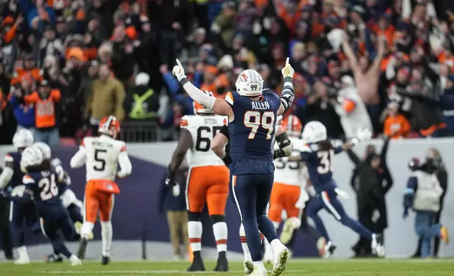 Denver Broncos defensive end Zach Allen (99) celebrates teammate cornerback Ja'Quan McMillian's 46-yard interception return for a touchdown during the second half of an NFL football game against the Cleveland Browns, Monday, Dec. 2, 2024, in Denver. (AP Photo/Jack Dempsey)