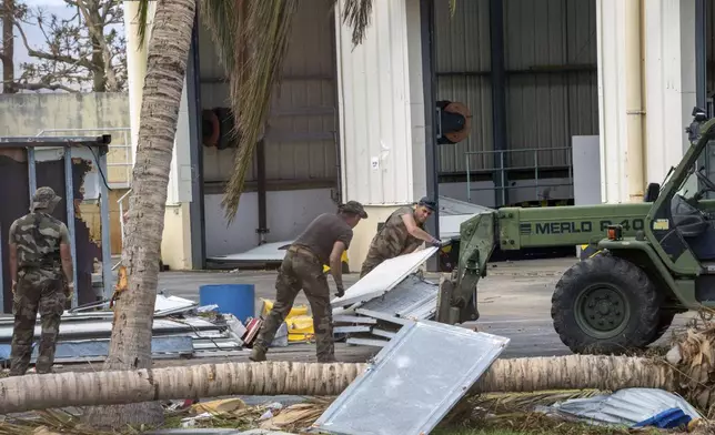 This photo provided by the French Army shows soldiers clearing a road in the Indian Ocean French territory of Mayotte, Wednesday Dec.18, 2024, as the cyclone on Saturday was the deadliest storm to strike the territory in nearly a century. (D Piatacrrea, Etat Major des Armees/Legion Etrangere via AP)