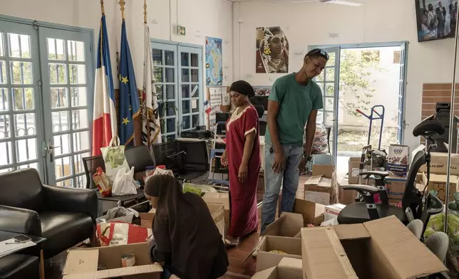 Volunteers sort through donations for victims of cyclone Chido in Mayotte at the House of Mayotte, in Saint-Denis, Réunion Island, Wednesday, Dec. 18, 2024. (AP Photo/Adrienne Surprenant)