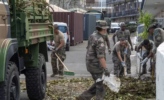 This photo provided by the French Army shows soldiers clearing a road in the Indian Ocean French territory of Mayotte, Wednesday Dec.18, 2024, as the cyclone on Saturday was the deadliest storm to strike the territory in nearly a century. (D Piatacrrea, Etat Major des Armees/Legion Etrangere via AP)