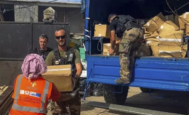 This photo provided by the French Interior Ministry shows French gendarmes unloading supplies in Koungou, in the Indian Ocean French territory of Mayotte, Wednesday Dec.18, 2024. (Ministere de l'Interieur/Gendarmerie Nationale via AP)