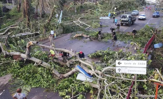 This undated photo provided Tuesday Dec. 17, 2024 by the French Interior Ministry shows gendarmes clearing a road in the French territory of Mayotte in the Indian Ocean, after the island was battered by its worst cyclone in nearly a century, (Ministere de l'Interieur/Gendarmerie Nationale via AP)