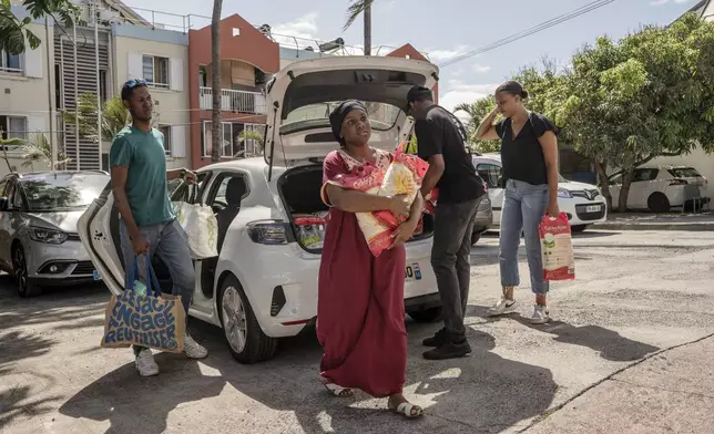 People bring goods for victims of cyclone Chido in Mayotte at the House of Mayotte, in Saint-Denis, Réunion Island, Wednesday, Dec. 18, 2024. (AP Photo/Adrienne Surprenant)