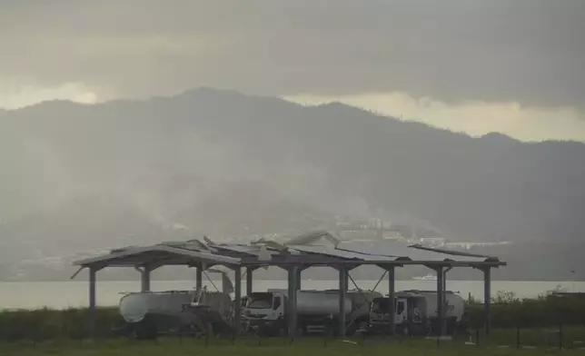 Smoke rises from destroyed dwellings Wednesday, Dec. 18, 2024 in the French Indian Ocean island of Mayotte. (AP Photo/Adrienne Surprenant)