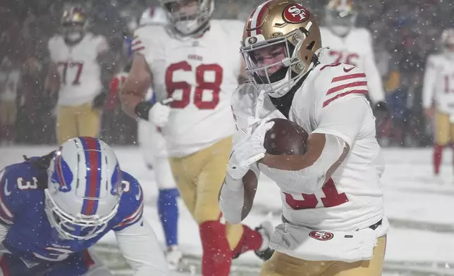 San Francisco 49ers running back Isaac Guerendo, right, runs for a touchdown past Buffalo Bills safety Damar Hamlin (3) during the second half of an NFL football game in Orchard Park, N.Y., Sunday, Dec. 1, 2024. (AP Photo/Gene J. Puskar)