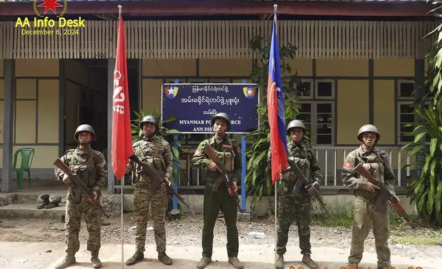 This photo released by the Arakan Army, shows members of the Arakan Army posing for a photograph in front of the captured district police office in Ann township, Rakhine state, Myanmar, Nov. 29, 2024. (The Arakan Army via AP)