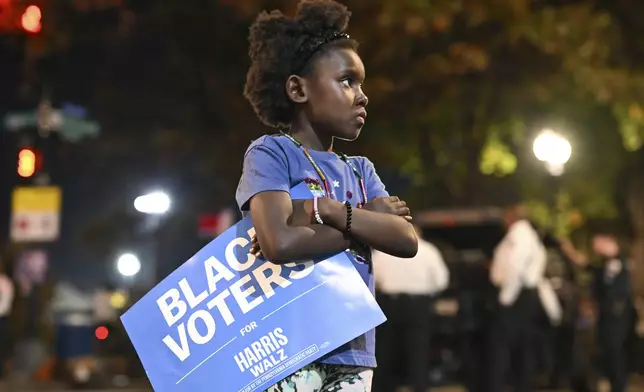 A young girl holds a "Black Voters for Harris-Walz" sign outside of Democratic presidential nominee Vice President Kamala Harris' election night watch party at Howard University, Tuesday, Nov. 5, 2024, in Washington. (AP Photo/Terrance Williams)