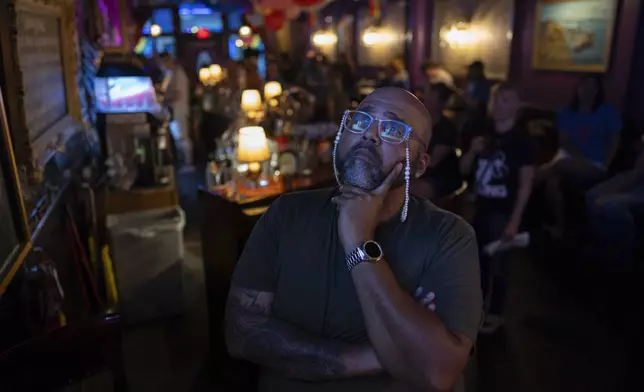 Jocardo Ralston, 47, from Pennsylvania, looks up to a television to watch the presidential debate between President Joe Biden and Republican presidential candidate former President Donald Trump at Tillie's Lounge on Thursday, June 27, 2024, in Cincinnati. (AP Photo/Carolyn Kaster)