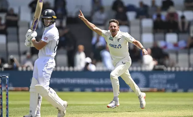 New Zealand's Nathan Smith, right, celebrates after taking the wicket of England's Jacob Bethell during play on day one of the second cricket test between New Zealand and England at the Basin Reserve in Wellington, New Zealand, Friday, Dec.6, 2024. (Andrew Cornaga/Photosport via AP)