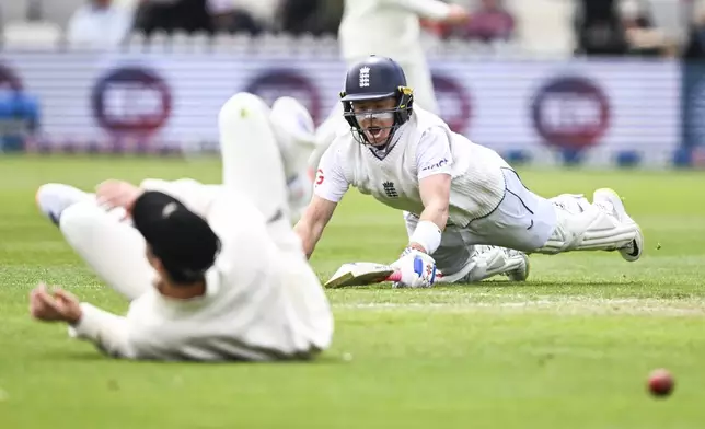 England's Ollie Pope dives to make his ground during play on day one of the second cricket test between New Zealand and England at the Basin Reserve in Wellington, New Zealand, Friday, Dec.6, 2024. (Andrew Cornaga/Photosport via AP)