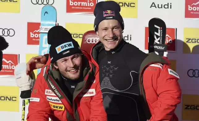 Switzerland's Alexis Monney poses with teammate Marco Odermatt after completing an alpine ski, men's World Cup downhill race, in Bormio, Italy, Saturday, Dec. 28, 2024. (AP Photo/Marco Trovati)