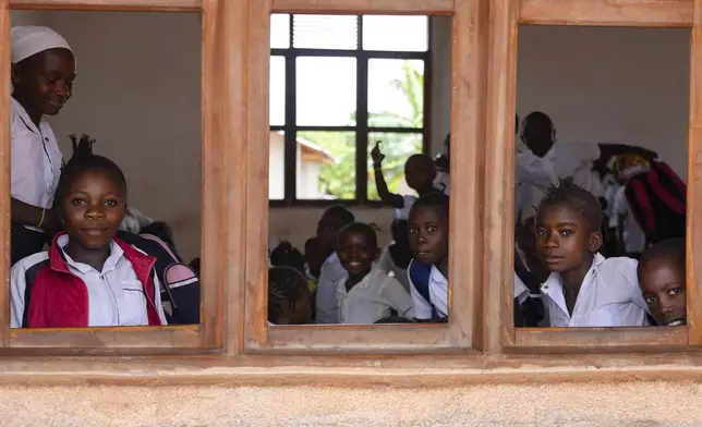 Children sit in a classroom with no windowpanes, built by a Chinese mining company, Kimia Mining, in Badengaido town in Congo, Sept. 23, 2024. (AP Photo/Sam Mednick)