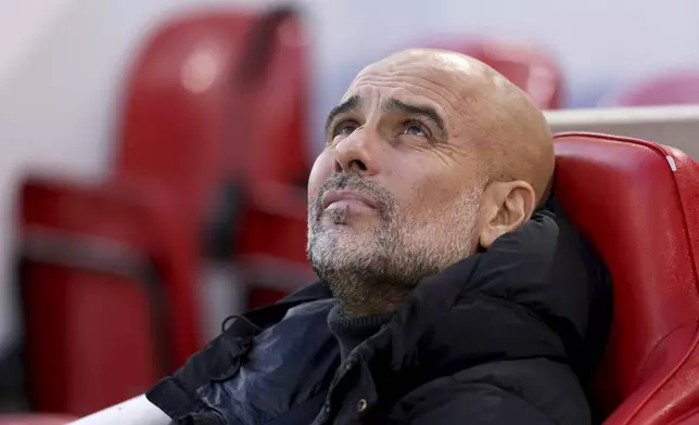 Manchester City's head coach Pep Guardiola sits on the bench before the English Premier League soccer match between Liverpool and Manchester City at Anfield Stadium, Liverpool, England, Sunday Dec. 1, 2024. (AP Photo/Ian Hodgson)