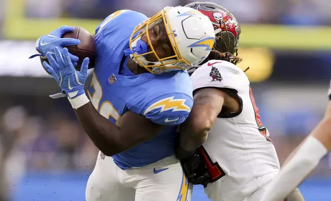 Los Angeles Chargers running back Kimani Vidal, left, is tackled by Tampa Bay Buccaneers linebacker J.J. Russell during the first half of an NFL football game Sunday, Dec. 15, 2024, in Inglewood, Calif. (AP Photo/Ryan Sun)