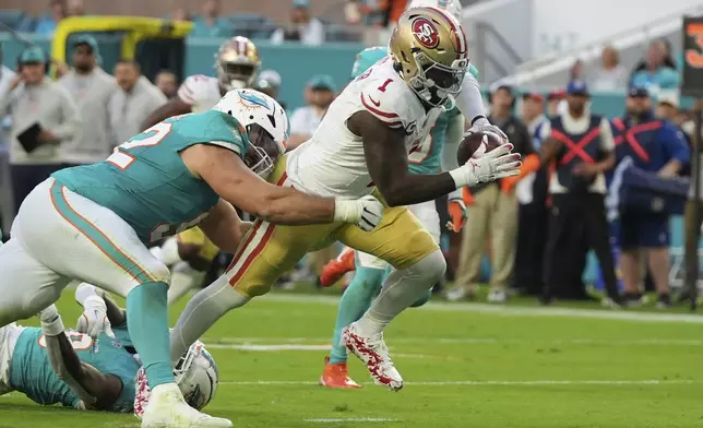 San Francisco 49ers wide receiver Deebo Samuel Sr. (1) breaks up a tackle by Miami Dolphins defensive tackle Zach Sieler (92) to score a touchdown during the first half of an NFL football game, Sunday, Dec. 22, 2024, in Miami Gardens, Fla. (AP Photo/Lynne Sladky)