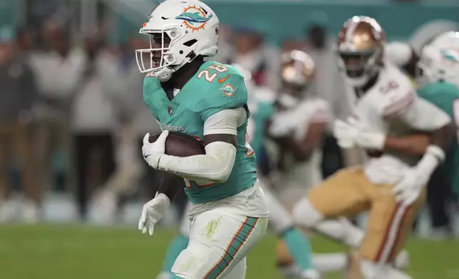 Miami Dolphins running back De'Von Achane (28) runs with the football during the second half of an NFL football game against the San Francisco 49ers, Sunday, Dec. 22, 2024, in Miami Gardens, Fla. (AP Photo/Lynne Sladky)