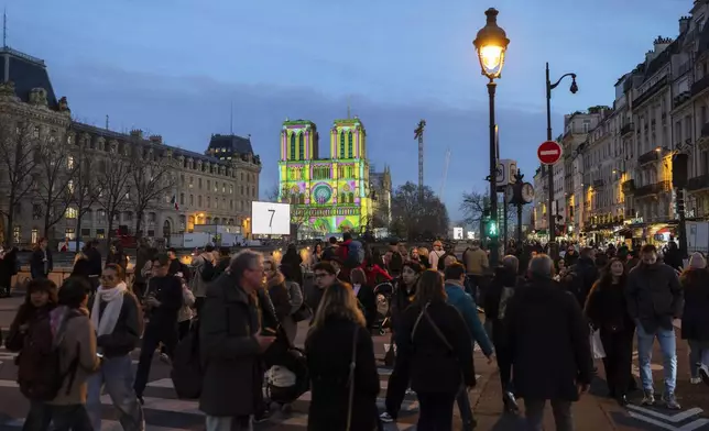 Pedestrians walk past Notre Dame Cathedral a day before its ceremonial reopening in Paris on Friday, Dec. 6, 2024, following the devastating fire of 2019. (AP Photo/Bernat Armangue)