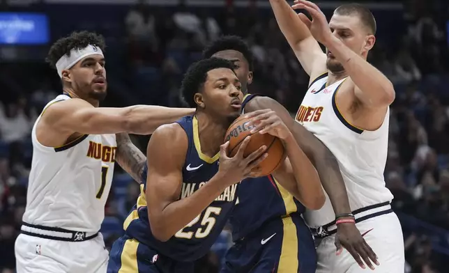 New Orleans Pelicans guard Trey Murphy III (25) looks to pass under pressure from Denver Nuggets forward Michael Porter Jr. (1) and center Nikola Jokic, right, in the first half of an NBA basketball game in New Orleans, Sunday, Dec. 22, 2024. (AP Photo/Gerald Herbert)