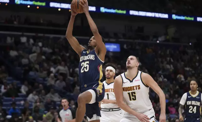 New Orleans Pelicans guard Trey Murphy III (25) goes to the basket ahead of Denver Nuggets center Nikola Jokic (15) and forward Michael Porter Jr. (1) in the first half of an NBA basketball game in New Orleans, Sunday, Dec. 22, 2024. (AP Photo/Gerald Herbert)