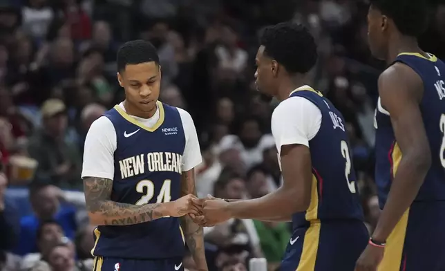 New Orleans Pelicans guard Jordan Hawkins (24) is congratulated by forward Herbert Jones (2) after making a 3-point basket in the first half of an NBA basketball game against the Denver Nuggets in New Orleans, Sunday, Dec. 22, 2024. (AP Photo/Gerald Herbert)