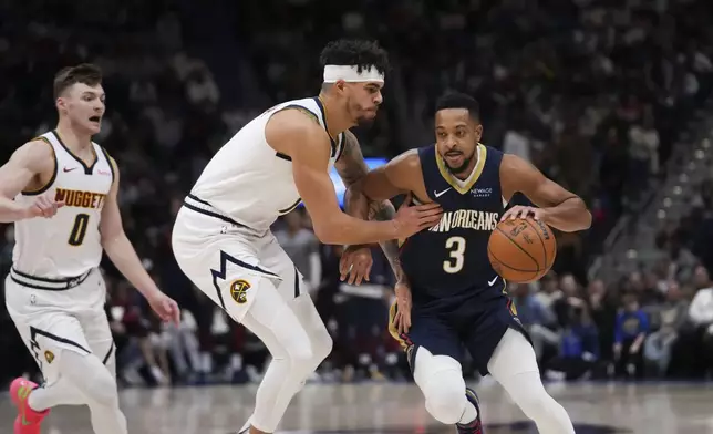 New Orleans Pelicans guard CJ McCollum (3) drives to the lane against Denver Nuggets forward Michael Porter Jr. in the first half of an NBA basketball game in New Orleans, Sunday, Dec. 22, 2024. (AP Photo/Gerald Herbert)