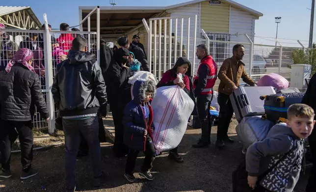 Syrians cross into Syria from Turkey at the Oncupinar border gate, near the town of Kilis, southern Turkey, on Tuesday, Dec. 17, 2024. (AP Photo/Khalil Hamra)