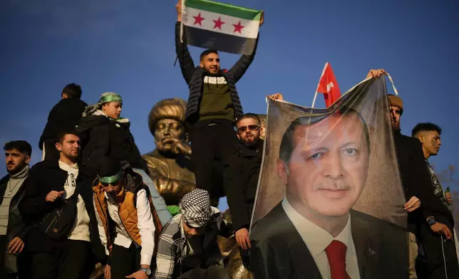 People hold a banner of Turkish President Recep Tayyip Erdogan as they celebrate the fall of the Syrian government in Istanbul, Turkey, on Sunday, Dec. 8, 2024. (AP Photo/Emrah Gurel)