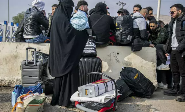 Syrian families wait at the Cilvegozu border gate to cross into Syria from Turkey near Antakya, southern Turkey, on Tuesday, Dec. 10, 2024. (AP Photo/Metin Yoksu)