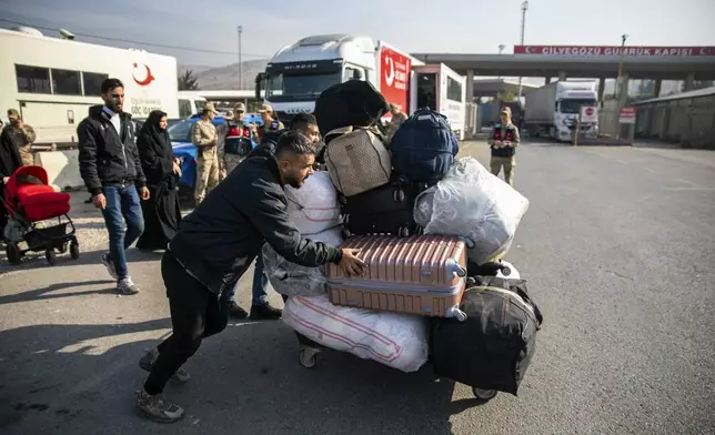 Syrian families arrive at the Cilvegozu border gate to cross into Syria from Turkey near Antakya, southern Turkey, on Tuesday, Dec. 10, 2024. (AP Photo/Metin Yoksu)