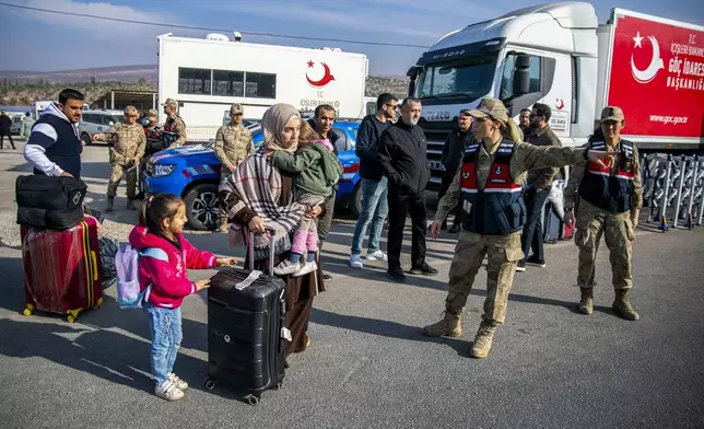 Syrian families arrive at the Cilvegozu border gate to cross into Syria from Turkey near Antakya, southern Turkey, on Tuesday, Dec. 10, 2024. (AP Photo/Metin Yoksu)