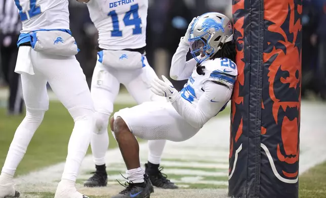 Detroit Lions running back Jahmyr Gibbs, right, celebrates his touchdown with Amon-Ra St. Brown (14) and Tim Patrick during the first half of an NFL football game against the Chicago Bears on Sunday, Dec. 22, 2024, in Chicago. (AP Photo/Erin Hooley)