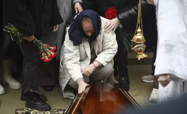 Yana Kshnyakina, widow of pilot in command Igor Kshnyakin mourns at the coffin during a funeral of crew members of the Azerbaijan Airlines Embraer 190 killed in a deadly plane crash in Kazakhstan this week, at the II Alley of Honor in Baku, Azerbaijan, Sunday, Dec. 29, 2024. (AP photo)