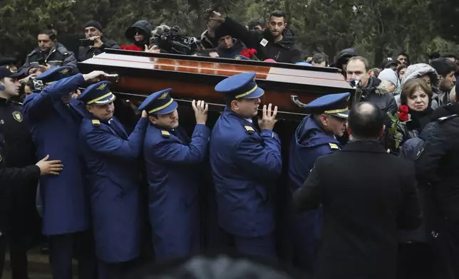 Pilots carry a coffin during a funeral of the crew members of the Azerbaijan Airlines Embraer 190 killed in a deadly plane crash in Kazakhstan this week, at the II Alley of Honor in Baku, Azerbaijan, Sunday, Dec. 29, 2024. (AP photo)