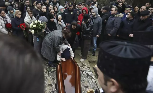 Yana Kshnyakina, widow of pilot in command Igor Kshnyakin mourns during a funeral of crew members of the Azerbaijan Airlines Embraer 190 killed in a deadly plane crash in Kazakhstan this week, at the II Alley of Honor in Baku, Azerbaijan, Sunday, Dec. 29, 2024. (AP photo)