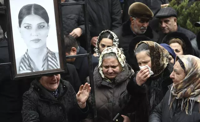 People mourn at the grave of flight attendant Hokume Aliyeva during a funeral of the crew members of the Azerbaijan Airlines Embraer 190 killed in a deadly plane crash in Kazakhstan this week, at the II Alley of Honor in Baku, Azerbaijan, Sunday, Dec. 29, 2024. (AP photo)