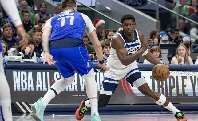 Minnesota Timberwolves guard Anthony Edwards (5) makes a move on Dallas Mavericks guard Luka Doncic (77) in the first half of an NBA basketball game on Wednesday, Dec. 25, 2024, in Dallas.(AP Photo/Emil T. Lippe)