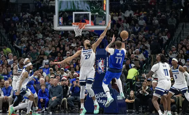 Dallas Mavericks guard Luka Doncic (77) attempts a shot over Minnesota Timberwolves center Rudy Gobert (27) in the first half of an NBA basketball game on Wednesday, Dec. 25, 2024, in Dallas. (AP Photo/Emil T. Lippe)