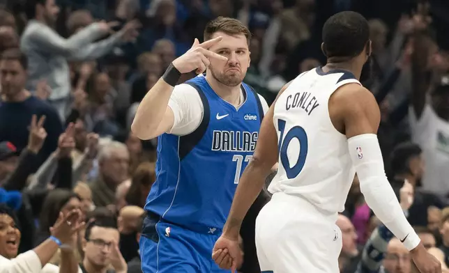 Dallas Mavericks guard Luka Doncic (77) celebrates after hitting a three-pointer over Minnesota Timberwolves guard Mike Conley (10) in the first half of an NBA basketball game on Wednesday, Dec. 25, 2024, in Dallas. (AP Photo/Emil T. Lippe)