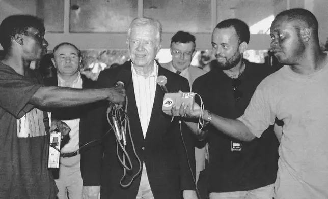 FILE - Former U.S. President Jimmy Carter talks with the press upon his arrival in Georgetown, Guyana, Oct. 3, 1992, to monitor the elections on Oct. 5. (AP Photo/Diego Giudice, File)