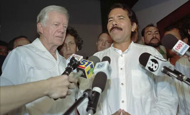 FILE - Former U.S. President Jimmy Carter, left, meets with Nicaraguan presidential candidate Daniel Ortega, of the Sandinista National Liberation Front, Oct. 19, 1996, in Managua, Nicaragua. (AP Photo/Brennan Linsley, File)