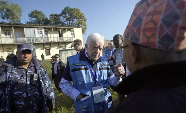 FILE - Former U.S. President Jimmy Carter, center, visits a polling station in Katmandu, Nepal, on Nov. 19, 2013. (AP Photo/Niranjan Shrestha, File)